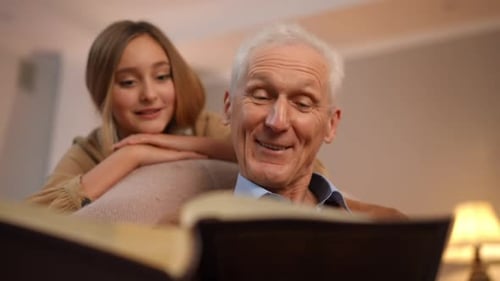 Retrato de un hombre mayor caucásico positivo hablando recordando recuerdos viendo un antiguo álbum de fotos con