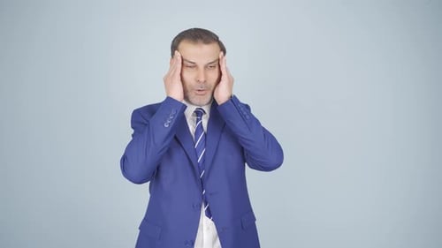 Man in Blue Suit Rubbing Temples