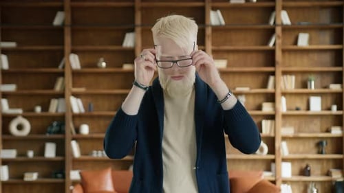 Homme d'affaires albinos portant des lunettes élégantes au bureau Homme croisant les bras