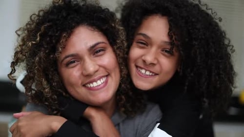 Mother and child smiling. Mixed race ethnicity daughter and parent