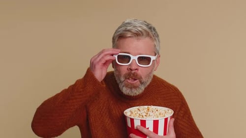 Enthusiastic Man Wearing 3D Glasses Eats Popcorn