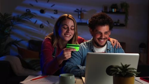 Young Couple Shops Online at Home at Night