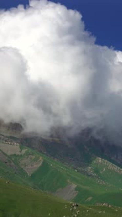 Clouds Enveloping Green Mountain in Vertical Landscape View
