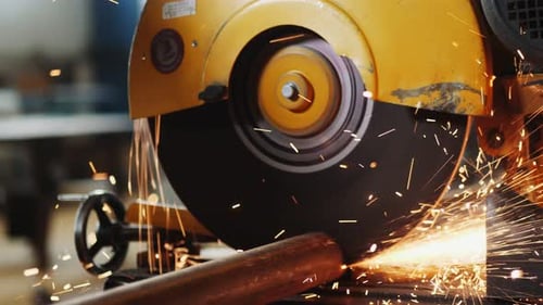 Arbeiter schneidet Metallrohr mit Säge in Nahaufnahme der Produktionsanlage