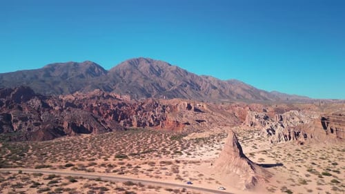 Aerial view drone flying over scenic red rocky mountains and arid desert