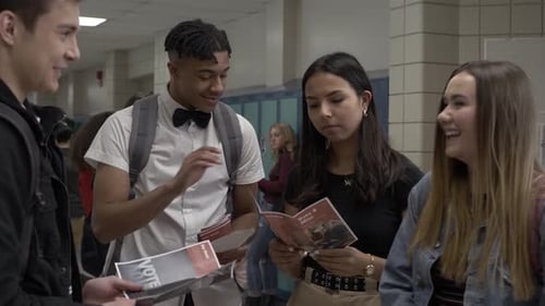 High School Students Looking at Voting Brochures in Corridor Adult
