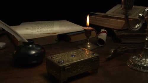 Old Desk With Ancient Manuscripts And Books In Candlelight