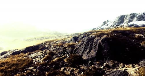 Mountain Landscape with Rocky Terrain and Grass Under Bright Light