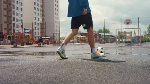 Athletic Man Dribbling Soccer Ball on Urban Court
