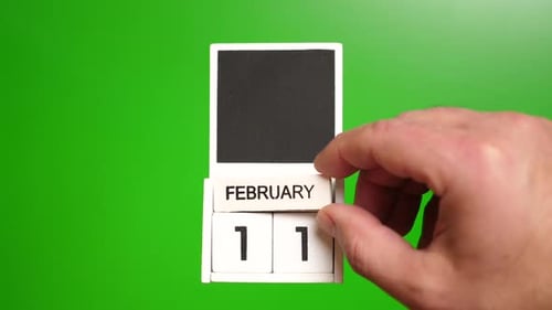Hand Turns a Calendar to February 11 on Green Screen