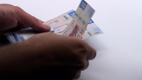 Imagem aproximada de um homem contando pesos mexicanos. Câmera lenta