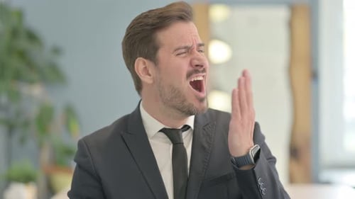 Portrait of Businessman Yawning in Office