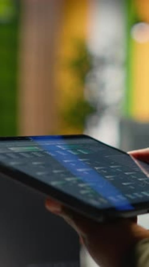 Vertikale Video-Nahaufnahme eines IT-Experten im Startup-Büro, der mit KI auf einem Tablet arbeitet