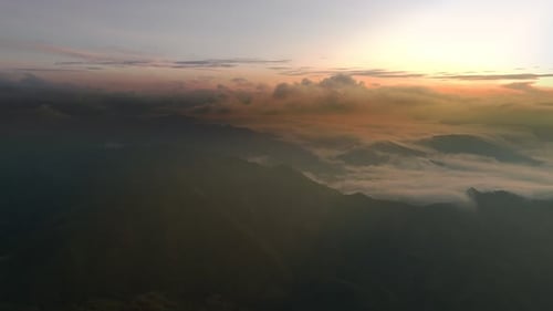 Drone Aerial View of Sunrise Over Mountains and Rolling Clouds