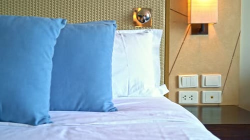 Comfortable Hotel Bedroom with Blue Pillows, Bedside Table