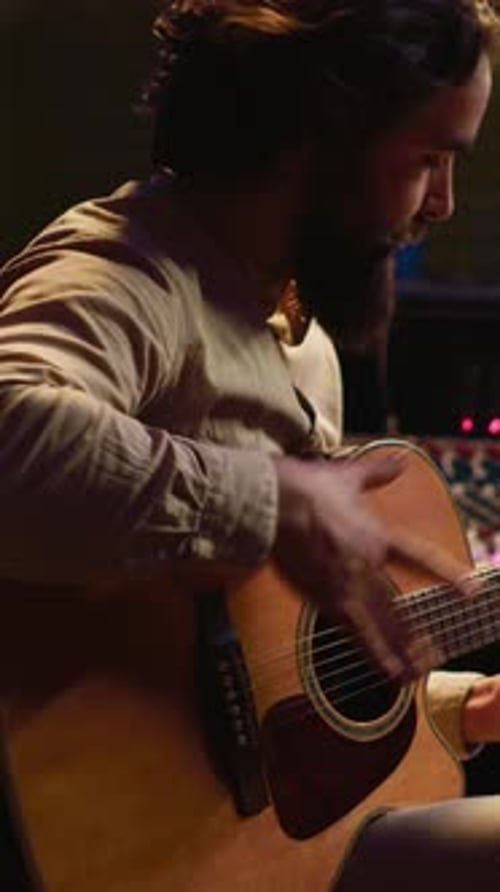 Vertikales Video: Junger Künstler und Songwriter komponiert in einer Aufnahmesession einen neuen Song auf der Gitarre