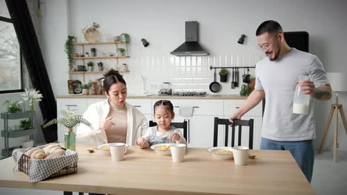 Family Enjoying Cereal Together in Bright Kitchen