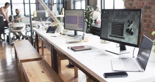 Espacio de oficina moderno diseñado para negocios, con varios escritorios, computadoras y un ambiente informal