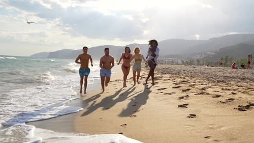 Happy friends running on the beach