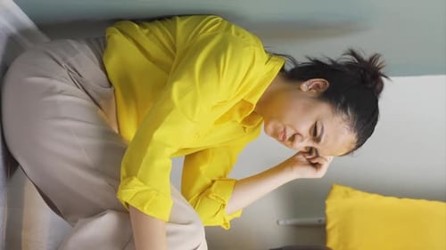 Distressed Woman With Headache Kneeling Indoors