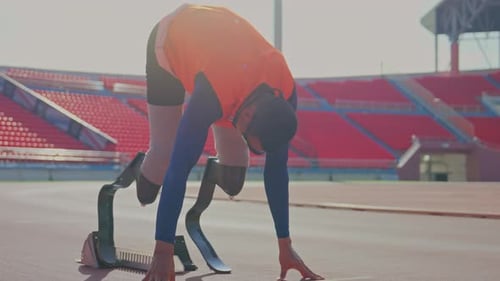 Close up sport man athlete prosthesis legs with orange cloth stay in the position of start running
