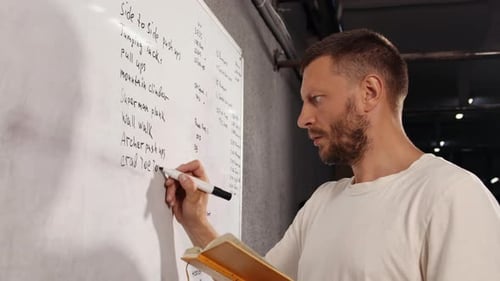 Man Writing Exercise List on Whiteboard
