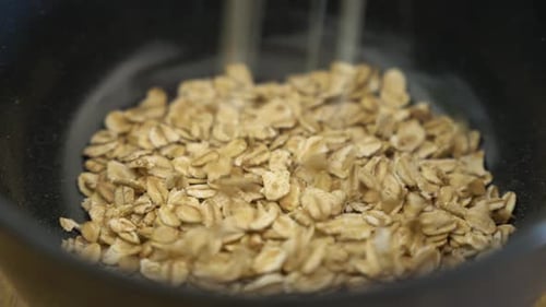 Oatmeal Pours into Bowl for Breakfast