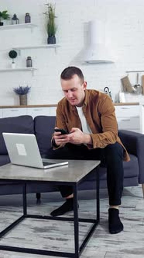 Man works on laptop at home. Young man working on laptop from home