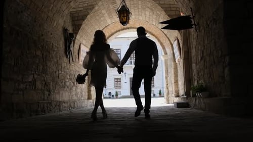 Silhouette of a Couple in Love Walking Under the Tunnel