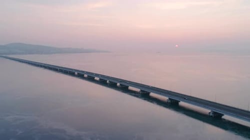 Drohnenaufnahme der Lowwater Bridge über die Bucht mit fahrendem Auto während des Sonnenuntergangs Aktiv