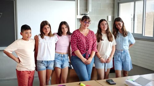 Happy Junior School Students Children Group Looking at Camera Standing in Classroom with Female