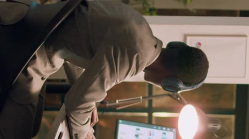 Vidéo verticale : Employé écoutant de la musique au travail