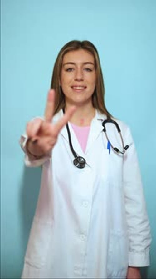 Female Doctor Gestures Two in White Coat