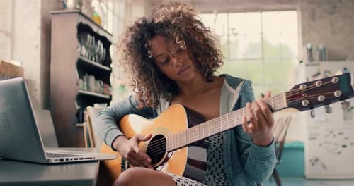 Woman Plays Guitar With Laptop at Home