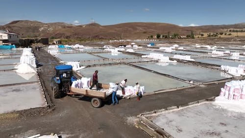 Aerial View Of Workers Working In Salt Ponds