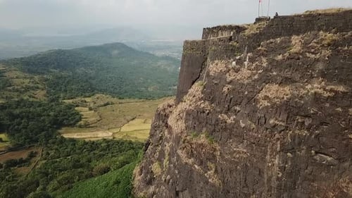 Aerial flight to end of Vinchu Kada hill fort high above Indian farms