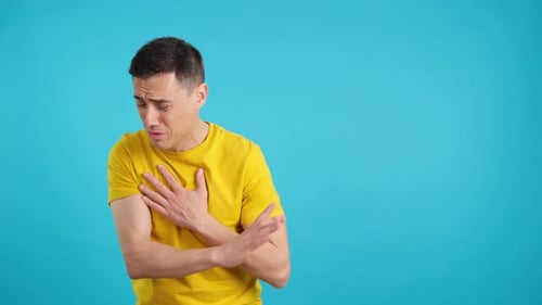 Un homme blessé fait un geste de la main pour rester à l'écart