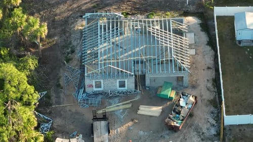 Vue d'en haut d'un ensemble de toit fabriqué à partir d'une charpente en acier sur une maison inachevée