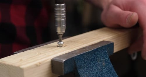 Close up clip of carpenter using electric screwdriver to screw out the nail out of the wood plank fo