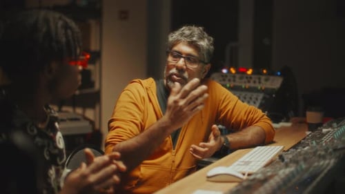 Black Musician and Sound Engineer Working Together in Recording Studio