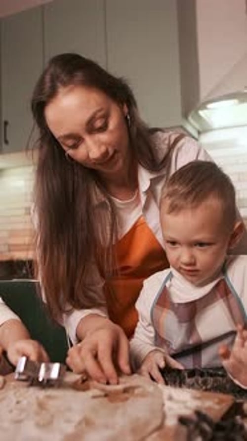 Mom and daughter baking gingerbread cookies together, creating a festive atmosphere of warmth and co