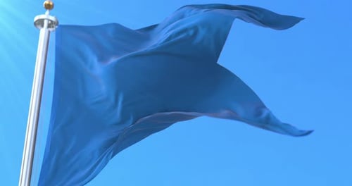 Waving Plain Blue Flag Against Clear Blue Sky