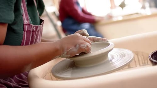 Potière afro-américaine utilisant un tour de potier dans un atelier de poterie, Ralentissement