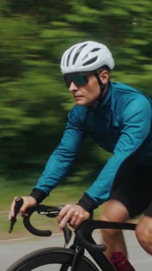Radfahrer mit Schutzhelm fährt mit dem Fahrrad durch den grünen Wald