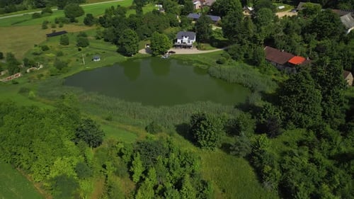 A Stunning Aerial View of a Tranquil Pond Nestled Amongst Lush Greenery and Picturesque Scenic Homes
