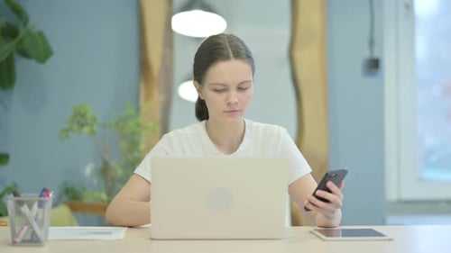 Young Woman Using Laptop and Smart Phone