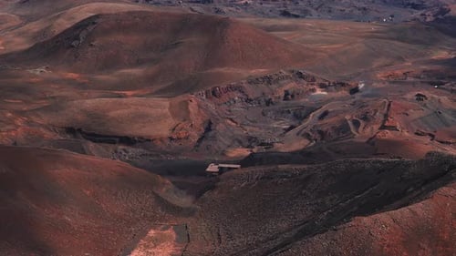Barrido aéreo del terreno volcánico rojo óxido en las Islas Canarias de Fuerteventura