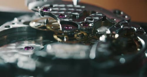 Slow motion macro close up of a professional watchmaker repairer working on a luxury mechanism wat