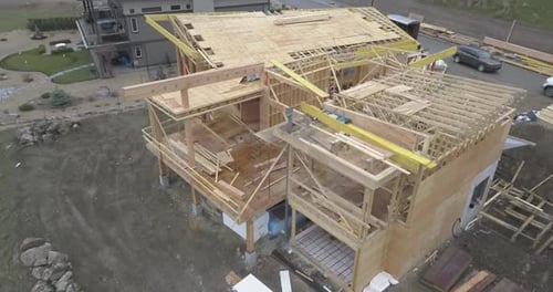 Una toma aérea con un Zumbido de una casa con vistas a un lago en construcción