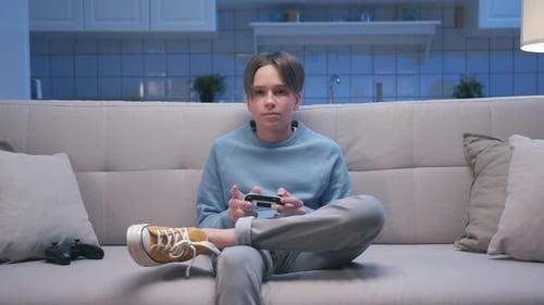 Teenager Relaxing on Couch and Playing Video Game
